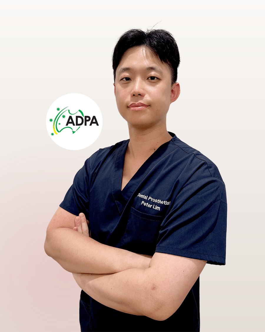 Peter Lim, dental prosthetist, in navy scrubs with his arms folded